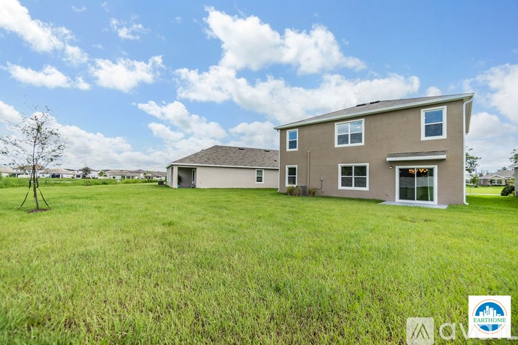 A two-story house with a large lawn in front.