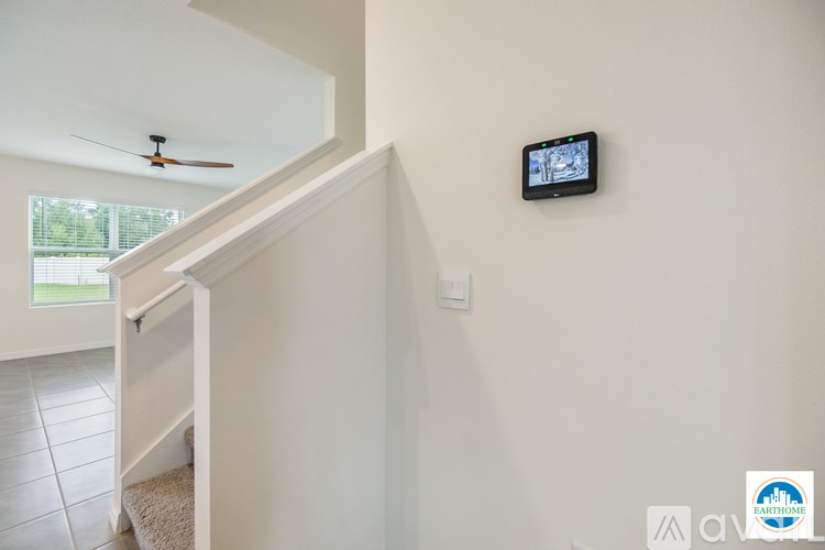 A wall-mounted television is mounted on a white wall.
