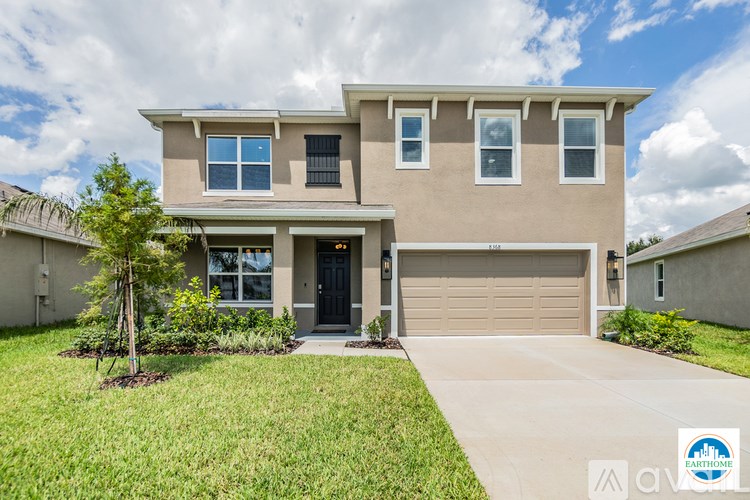A two-story house with a garage and a front yard.
