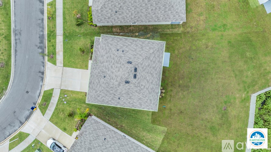 A bird's eye view of a residential area with houses and a road.