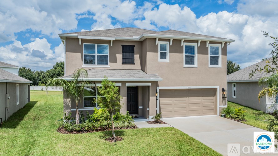 A two-story house with a garage and a driveway.