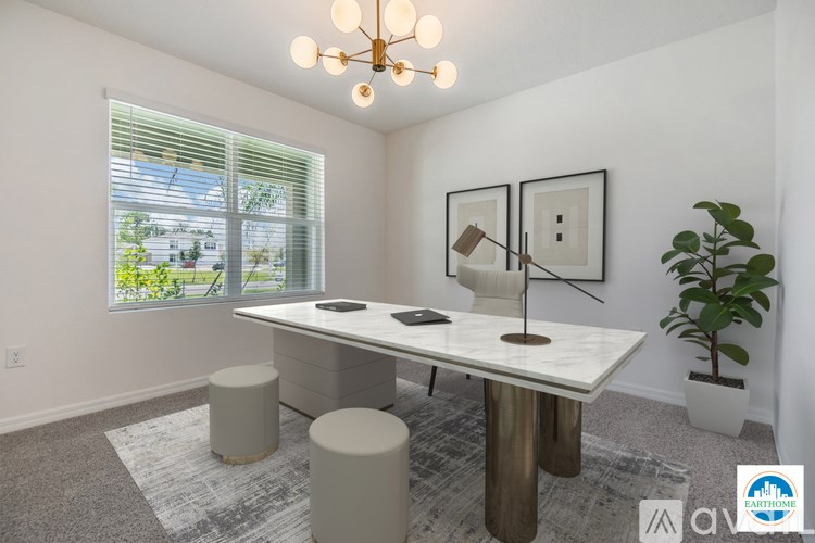 A well-lit room with a table, chairs, and a potted plant.