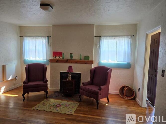 A living room with two chairs and a fireplace.