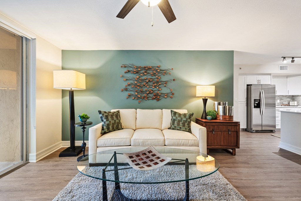 a living room with a white couch and a glass table