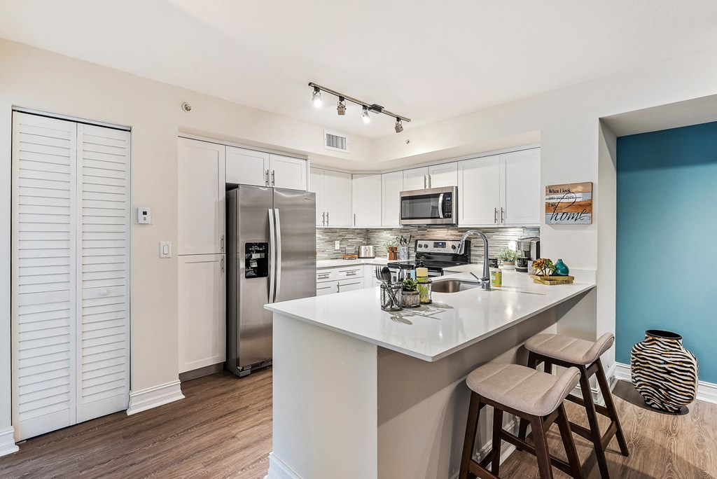 a kitchen with a large island and stainless steel appliances