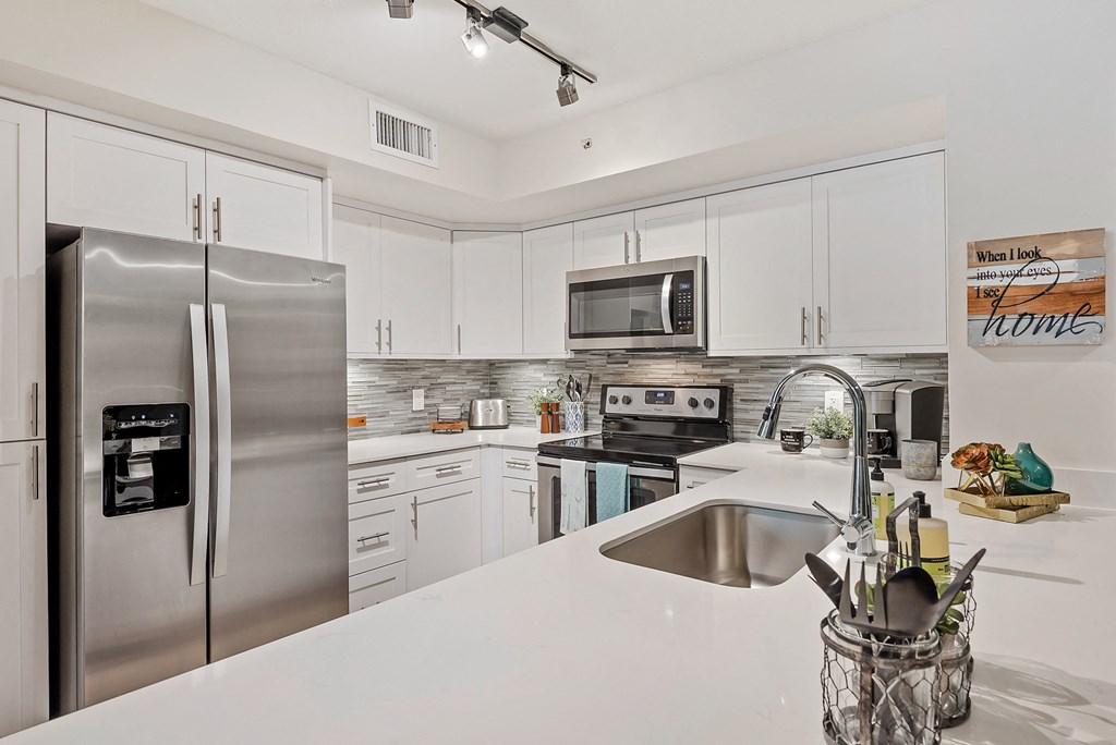 a kitchen with stainless steel appliances and white counter tops