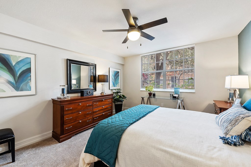 a bedroom with a large bed and a ceiling fan