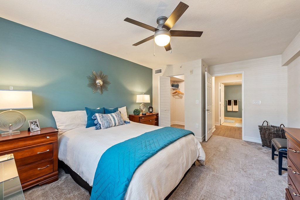 a bedroom with a large bed and a ceiling fan