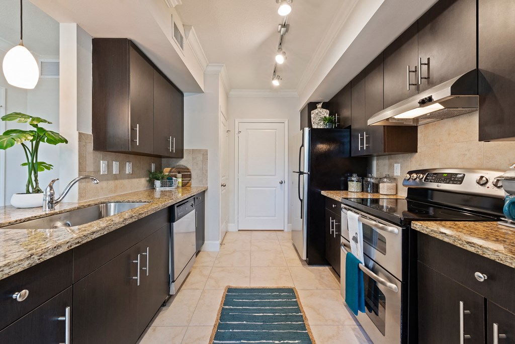 a kitchen with stainless steel appliances and marble counter tops