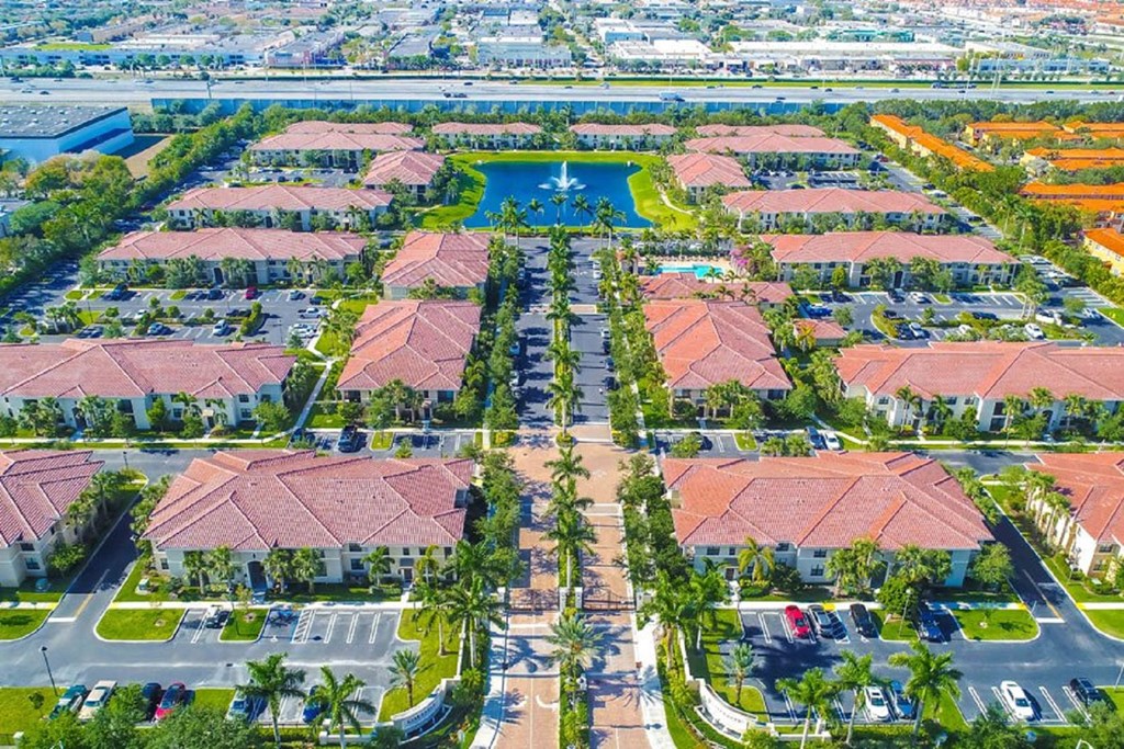 an aerial view of a parking lot with houses and cars