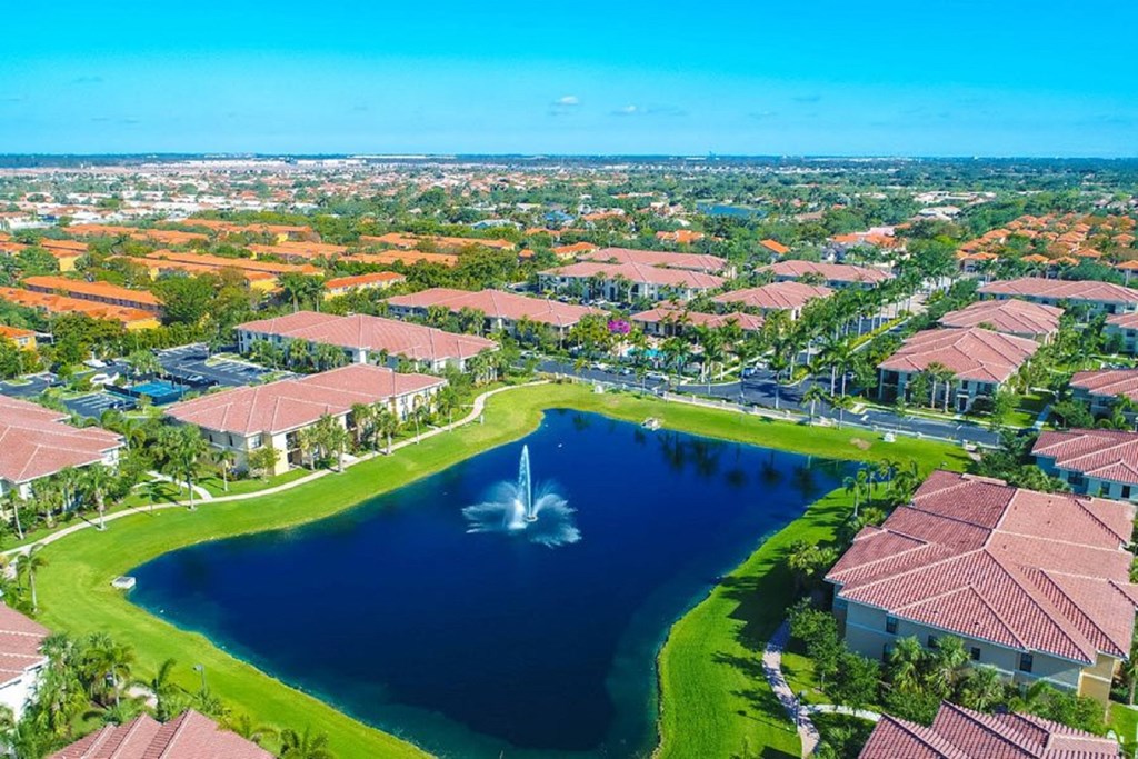 a large pond with a fountain in the middle of a residential area