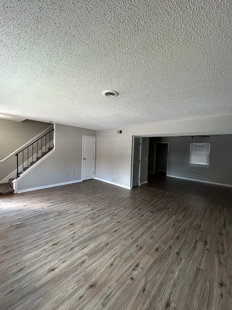 A room with wooden flooring and a staircase.