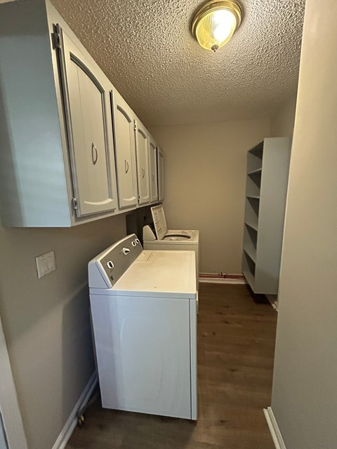 A white washing machine sits in a laundry room.