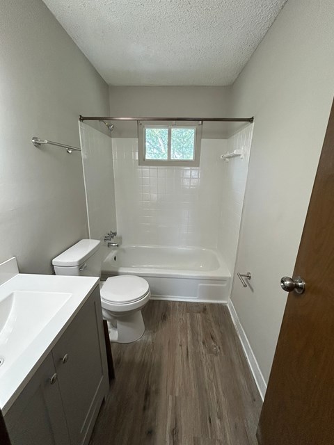 A white toilet is next to a white sink in a small bathroom.