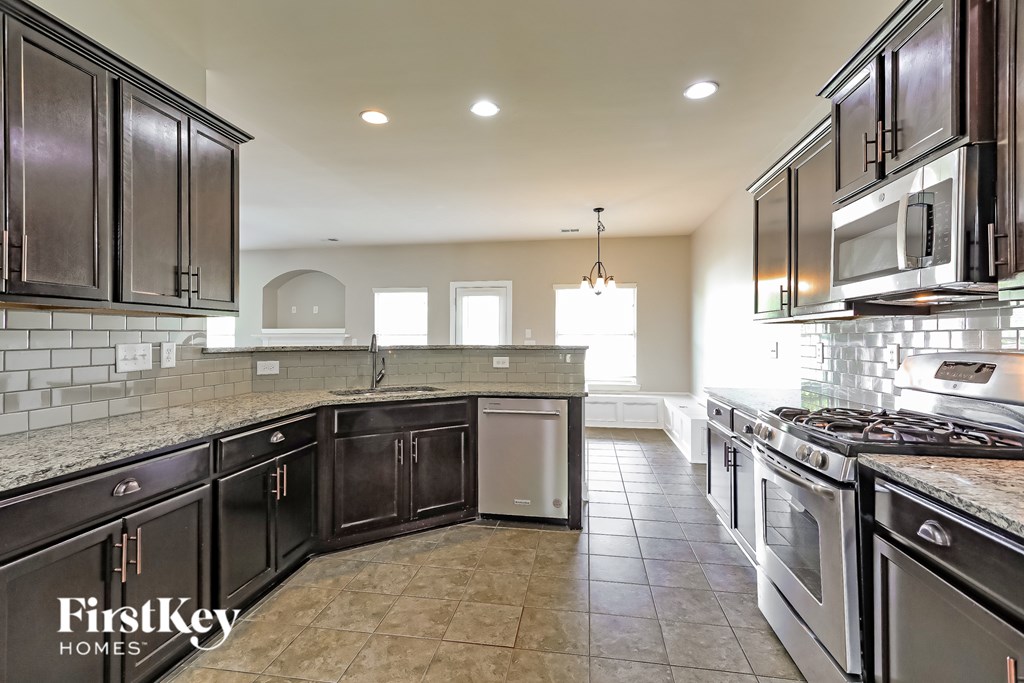 A kitchen with dark brown cabinets and a tile floor.