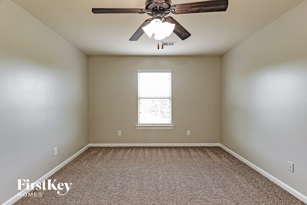 A room with a ceiling fan and a window.