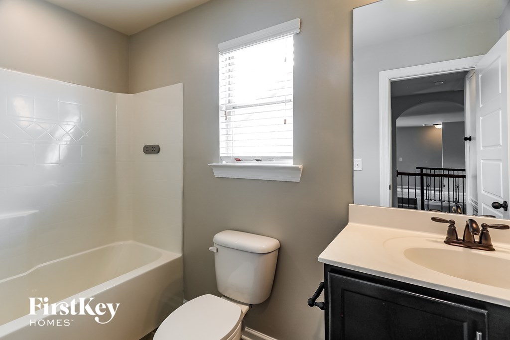 A bathroom with a toilet, sink, and bathtub.