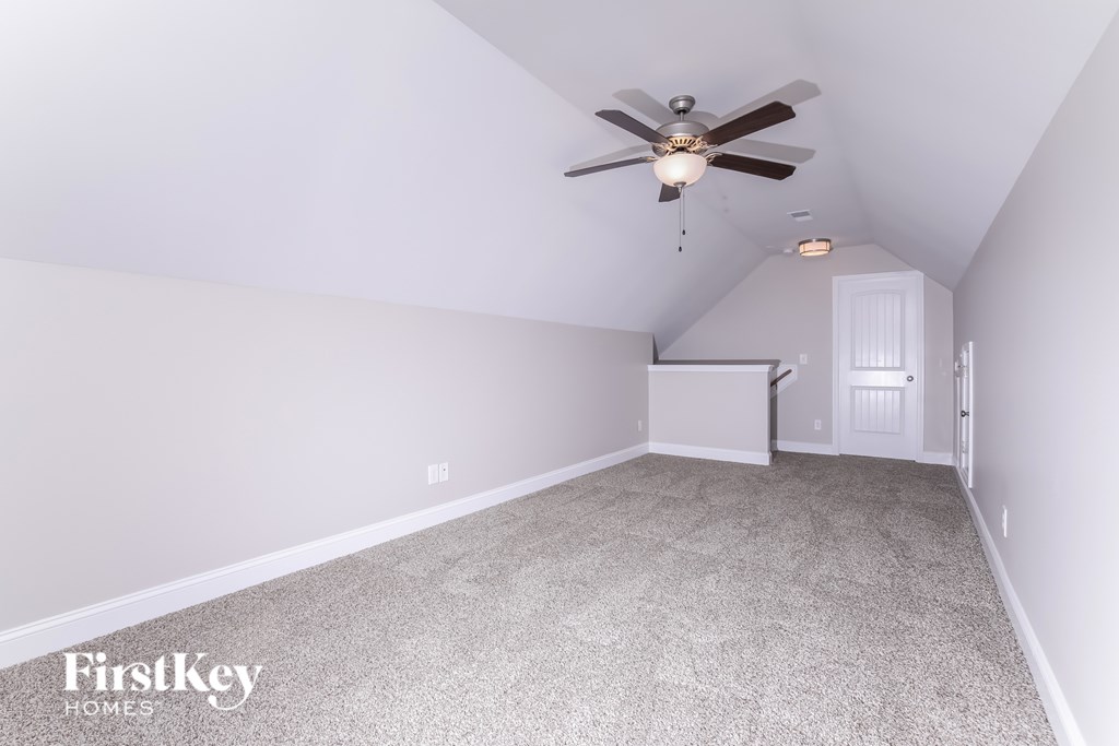 A room with a ceiling fan and a carpeted floor.