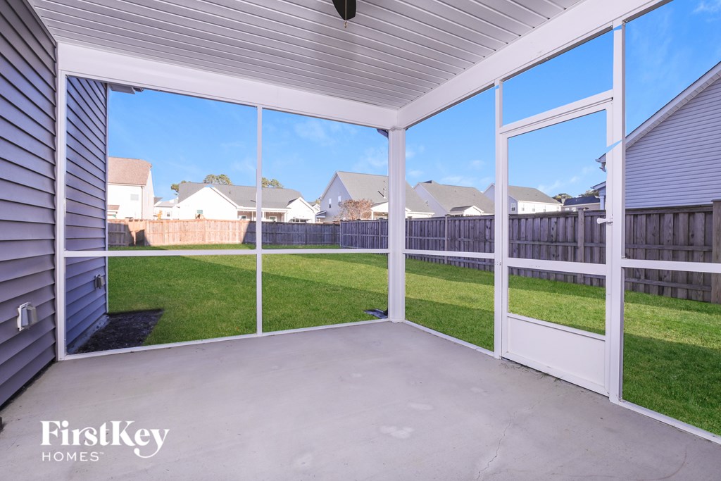 A sunny day in a backyard with a white fence.