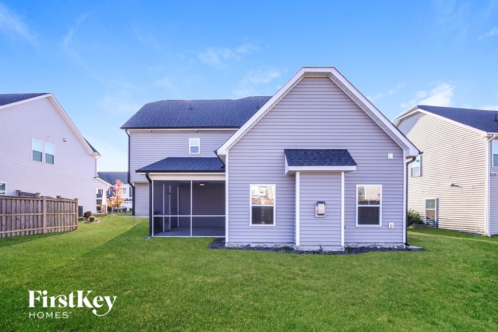 A house with a blue roof and a fence in the front yard.
