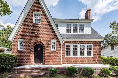 A brick house with a black door and white trim.