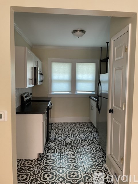A kitchen with black and white tiles on the floor.