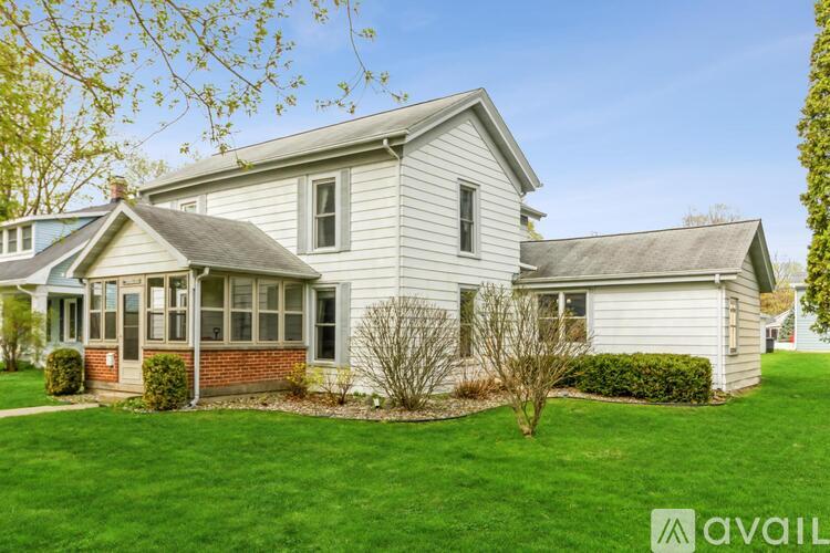 A house with a well-maintained lawn and a clear sky in the background.