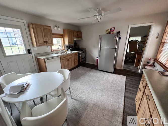 A kitchen with a white table and chairs.