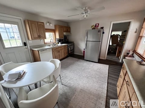A kitchen with a white table and chairs.
