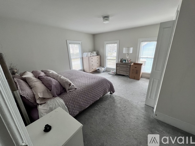 A bedroom with a bed, dresser, and window.