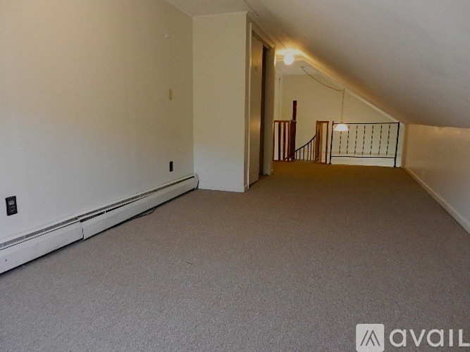 A spacious room with a staircase leading to another level.