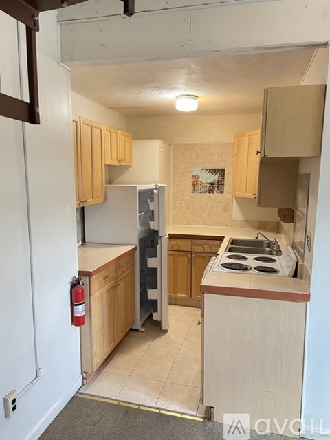 A kitchen with wooden cabinets and a stove top oven.