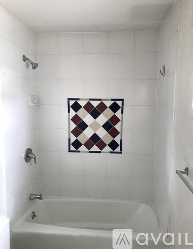 A white bathroom with a white tub and a white shower.