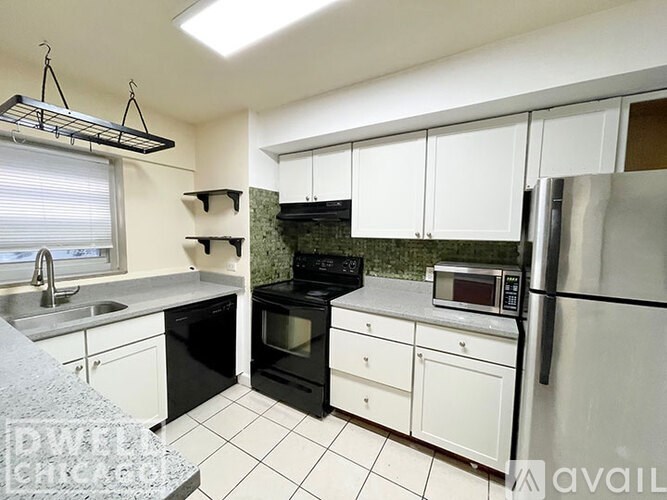 A kitchen with black appliances and white cabinets.