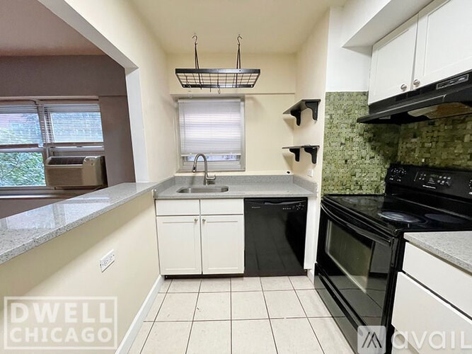 A kitchen with black appliances and white cabinets.
