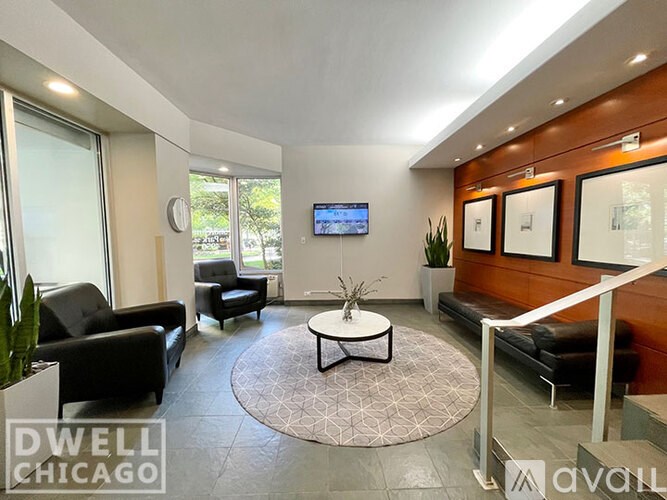 A living room with a couch, chair, and television.