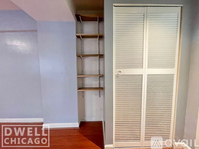 A room with a white door and a wooden floor.