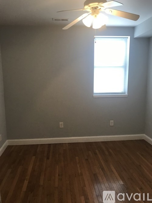 A room with a ceiling fan and a window.