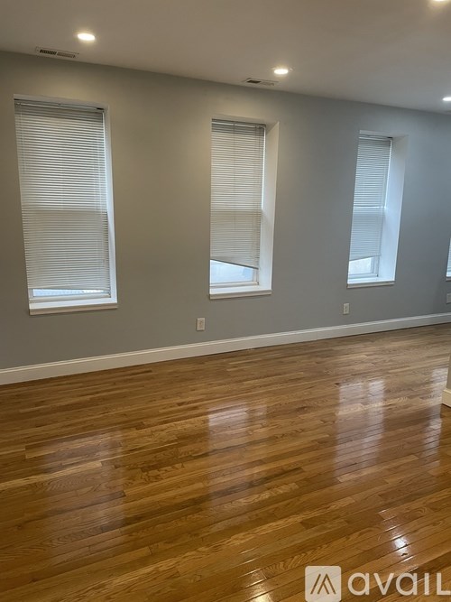 A room with wooden floors and two windows.