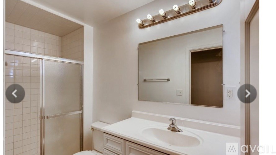 A bathroom with a white sink and a mirror above it.