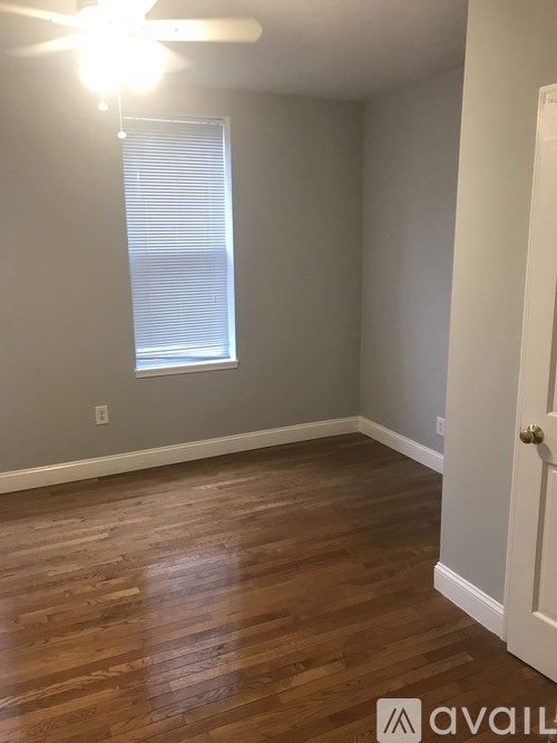 A room with wooden flooring and a ceiling fan.