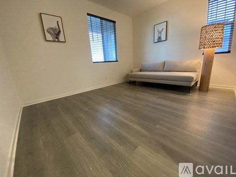 A living room with a white couch and two pictures on the wall.