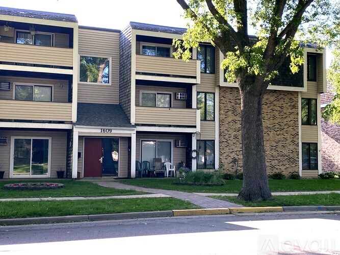 Apartment building with a tree in front of it.