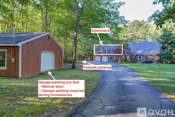 A red building with a garage door is labeled as "Apartment" and is situated next to a driveway that leads to another building.
