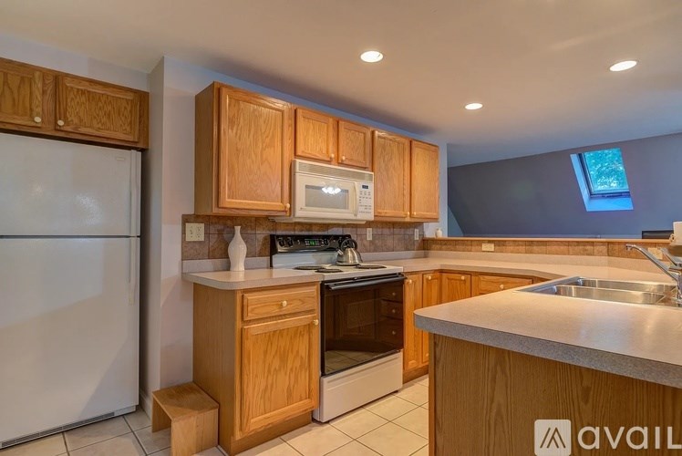 A kitchen with wooden cabinets and a white refrigerator.