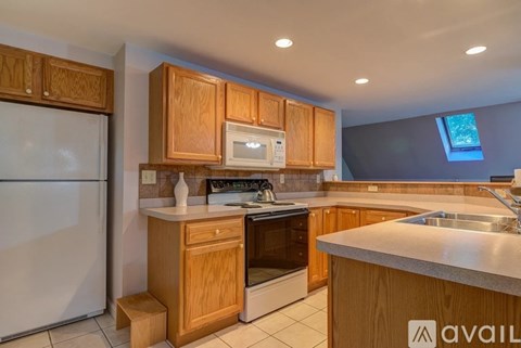 A kitchen with wooden cabinets and a white refrigerator.
