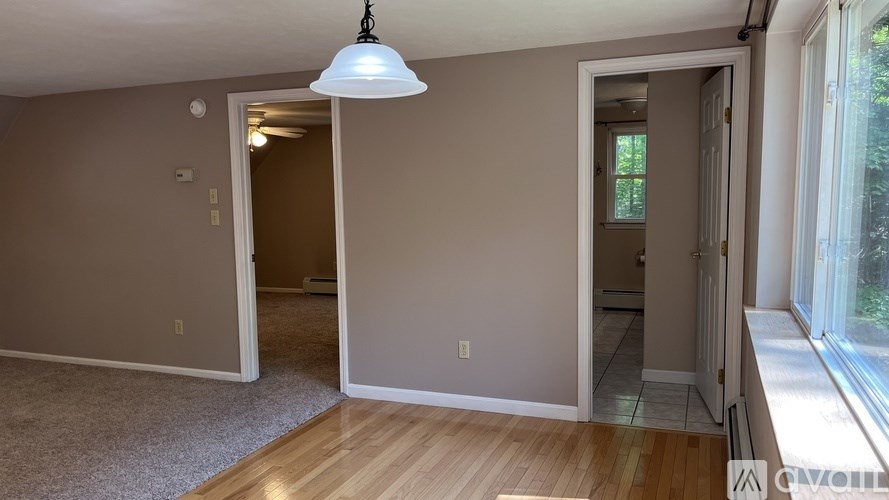 A room with a carpeted floor and a wooden door.