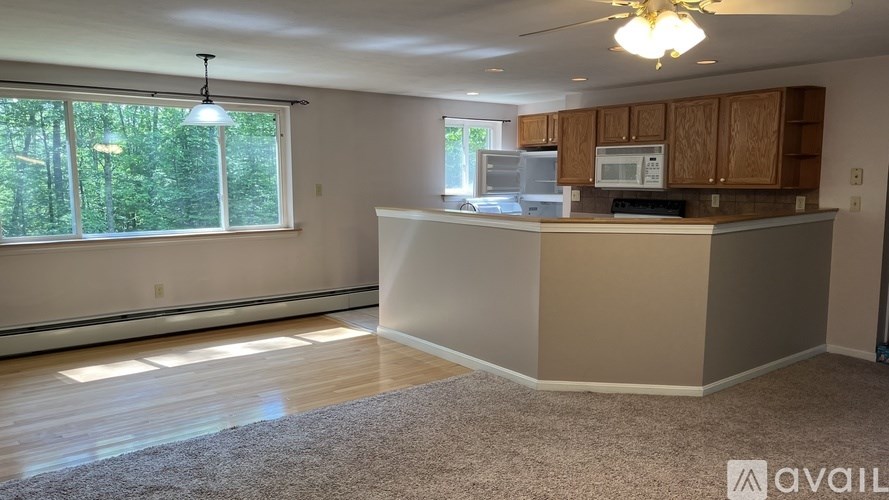 A kitchen with wooden cabinets and a microwave on the counter.