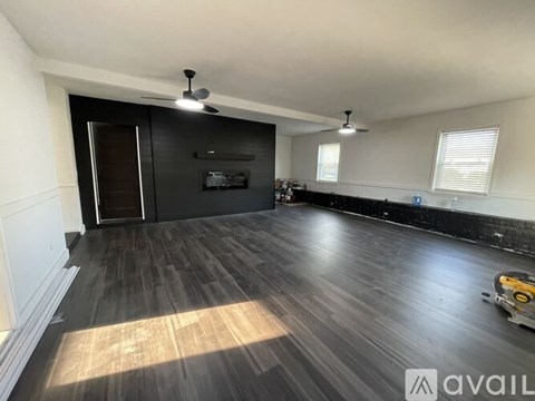 A room with wooden flooring and a black door.