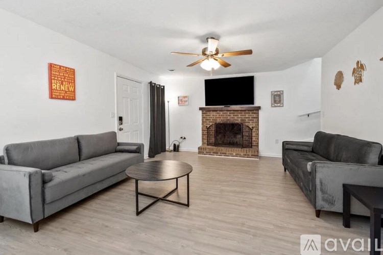 A living room with a grey couch, a coffee table, and a fireplace.